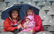 8 June 2014; Two year old Rebecca Mallon, from Naas, Co Kildare, with her mother Catherine and Deirdre McGrane, from Bohernabreena, Dublin, shelter from a shower in the Cusack Stand. Picture credit: Ray McManus / SPORTSFILE