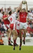 24 June 2006; Martin Farrelly, Louth, fields the ball ahead of team-mate Paddy Keenan, Sean Cavanagh and Colin Holmes, Tyrone. Bank of Ireland All-Ireland Senior Football Championship Qualifier, Round 1 Replay, Tyrone v Louth, Healy Park, Omagh, Co. Tyrone. Picture credit: Brendan Moran / SPORTSFILE