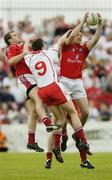 24 June 2006; Martin Farrelly, Louth, fields the ball ahead of team-mate Paddy Keenan and Tyrone's Sean Cavanagh and Colin Holmes. Bank of Ireland All-Ireland Senior Football Championship Qualifier, Round 1 Replay, Tyrone v Louth, Healy Park, Omagh, Co. Tyrone. Picture credit: Brendan Moran / SPORTSFILE