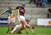 25 June 2014; Wexford's Conor McDonald scores his side's first goal despite the attempts of Offaly's Dan Kelleher. Bord Gáis Energy Leinster GAA Hurling Under 21 Championship, Semi-Final, Wexford v Offaly, Wexford Park, Wexford. Picture credit: Matt Browne / SPORTSFILE