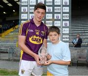 25 June 2014; Wexford's Conor McDonald is presented with the Player of the Match Award by 10 year old Oisin Carroll, from Ballycumber, Co. Offaly. Bord Gáis Energy Leinster GAA Hurling Under 21 Championship, Semi-Final, Wexford v Offaly, Wexford Park, Wexford. Picture credit: Matt Browne / SPORTSFILE