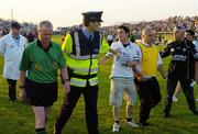 15 July 2006; Referee Michael Ryan is escorted off the pitch by a member of an Garda Siochana while being confronted by Sligo supporters. Bank of Ireland All-Ireland Senior Football Championship Qualifier, Round 3, Sligo v Westmeath, Markievicz Park, Sligo. Picture credit: Pat Murphy / SPORTSFILE