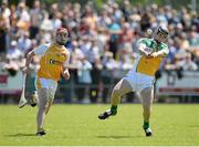 29 June 2014: Dan Currams, Offaly, scores a point dispite the pressure of Conor McCann, Antrim. GAA Hurling All-Ireland Senior Championship, Round 1, Antrim v Offaly, Ballycastle, Co. Antrim. Picture credit: Oliver McVeigh / SPORTSFILE