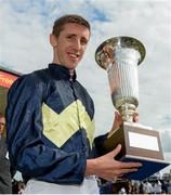 29 June 2014: Jockey George Baker holds up the Pretty Polly Stakes trophy after winning the Newbridge Silverware Pretty Polly Stakes on Thistle Bird. Curragh Racecourse, The Curragh, Co. Kildare. Picture credit: Barry Cregg / SPORTSFILE