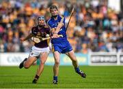 5 July 2014; Tony Kelly, Clare, scores a point under pressure from Wexford's Ian Byrne to make the score 2-23 to 2-21 in favour of Clare. GAA Hurling All-Ireland Senior Championship, Round 1, Clare v Wexford, Cusack Park, Ennis, Co. Clare. Picture credit: Ray McManus / SPORTSFILE