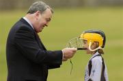 28 July 2006; GAA President Nickey Brennan fixes the helmet of 9 year old Joanne Connelly during The Vhi Cul Camps, the official GAA summer camps, got off to a flying start all around the country at the start of July and are now in full swing with up to 75,000 children expected to attend the camps nationwide between July 3rd and 25th August. Bagenalstown, Co. Carlow. Picture credit; Matt Browne / SPORTSFILE