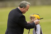 28 July 2006; GAA President Nickey Brennan fixes the helmet of 9 year old Joanne Connelly during The Vhi Cul Camps, the official GAA summer camps, got off to a flying start all around the country at the start of July and are now in full swing with up to 75,000 children expected to attend the camps nationwide between July 3rd and 25th August. Bagenalstown, Co. Carlow. Picture credit; Matt Browne / SPORTSFILE