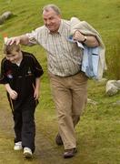 5 August 2006; GAA President Nickey Brennan makes his way to the start with Cathal Hamilton, age 10, from Blackrock, Co. Louth. M Donnelly All-Ireland Poc Fada Final, Annaverna Mountain, Ravensdale, Co Louth. Picture credit; Brian Lawless / SPORTSFILE