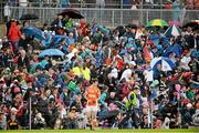 6 July 2014; Spectators shelter from the rain during the match. Ulster GAA Football Senior Championship, Semi-Final Replay, Armagh v Monaghan, St Tiernach's Park, Clones, Co. Monaghan. Picture credit: Piaras Ó Mídheach / SPORTSFILE