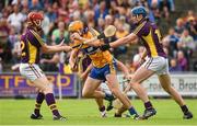 12 July 2014; Cian Dillon, Clare, clears under pressure from Diarmuid O'Keeffe, left, Conor McDonald, hidden, and Jack Guiney, Wexford. GAA Hurling All-Ireland Senior Championship Round 1 Replay, Clare v Wexford, Wexford Park, Wexford. Picture credit: Ray McManus / SPORTSFILE