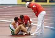13 August 2006; Ireland's Alistair Cragg is attended to by officials after pulling out of the Men's 5000m Final with an achilles tendon injury. SPAR European Athletics Championships, Ullevi Stadium, Gothenburg, Sweden. Picture credit; Brendan Moran / SPORTSFILE
