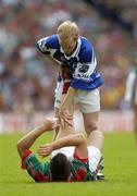 13 August 2006; Donal Brennan, Laois, assists Dermot Geraghty, Mayo, near the end of the game. Bank of Ireland All-Ireland Senior Football Championship Quarter-Final, Mayo v Laois, Croke Park, Dublin. Picture credit; Ray McManus / SPORTSFILE