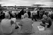 28 July 2014; (Editors please note; This black & white image has been created from an original colour file) A view of racegoers studying the form ahead of the Radissonhotelgalway.com & Galwaybayhotel.com Novice Hurdle. Galway Racing Festival, Ballybrit, Co. Galway. Picture credit: Barry Cregg / SPORTSFILE