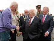 30 July 2014; The President of Ireland Michael D. Higgins is greeted by Martin Garry, from Partry, Co. Mayo, after arriving for thew day's races with manager of Ballybrit racecourse John Moloney, right. Galway Racing Festival, Ballybrit, Co. Galway. Picture credit: Barry Cregg / SPORTSFILE