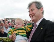 31 July 2014; JP McManus, owner of Thomas Edison, who won the Guinness Galway Hurdle Handicap with Tony McCoy poses for a photograph with young supporter Conor Jordan, aged 6 months, from Navan, Co. Meath. Galway Racing Festival, Ballybrit, Co. Galway. Picture credit: Barry Cregg / SPORTSFILE