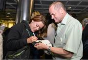 18 August 2014; Ireland's Lynne Cantwell signs an autograph for a supporter in Dublin Airport on her return from the Women's Rugby World Cup in France. Dublin Airport, Dublin. Picture credit: Ramsey Cardy / SPORTSFILE