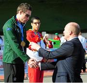 19 August 2014; Team Ireland's Jason Smyth, from Eglinton, Co. Derry, is presented with his gold medal after winning the men's 100m - T12 final, with a time of 10.78. 2014 IPC Athletics European Championships, Swansea University, Swansea, Wales. Picture credit: Chris Vaughan / SPORTSFILE