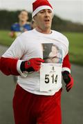17 December 2006; Eddie Carey, from Coolock, Dublin, running in memory of his uncle William Browne, in action during the Aware 10K Christmas Fun Run. Papal Cross, Phoenix Park, Dublin. Picture credit: Tomas Greally / SPORTSFILE *** Local Caption ***