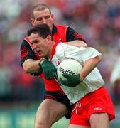 28 July 1996; Adrian Cush of Tyrone is tackled during the Ulster Senior Football Championship Final between Tyrone and Down at St. Tiernach's Park in Clones. Photo by David Maher/Sportsfile