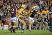 13 September 2014; Aaron Cunningham, Clare, shoots past Andrew Kenny, left, and Liam Ryan, Wexford, to score his side's first goal of the match. Bord Gáis Energy GAA Hurling Under 21 All-Ireland 'A' Championship Final, Clare v Wexford. Semple Stadium, Thurles, Co. Tipperary. Picture credit: Ray McManus / SPORTSFILE