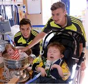 22 September 2014; Caoimhe Spillane, aged 4 months, and Padraig O'Donoghue, from Killarney, with Kerry footballers, David Moran, left, and James O'Donoghue, during a visit by the All Ireland Senior & Minor Football Champions 2014 to Our Lady's Children Hospital. Our Lady's Children Hospital, Crumlin, Dublin. Picture credit: Piaras Ó Mídheach / SPORTSFILE