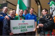 21 September 2014; Team Ireland's soccer player Ross O'Connor, from Tullamore, Co. Offaly, and a member of Tullamore Special Olympics Club, is welcomed by Pat Middleton from St Colmcille's Pipe Band, Tullamore and his fellow clubmates, pictured at Dublin Airport on his return from the 2014 Special Olympics European Games in Antwerp, Belgium. Dublin Airport, Dublin. Picture credit: Tomás Greally / SPORTSFILE