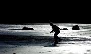 7 March 2004; A person plays hurling on the beach at Loughshinny in Dublin. Photo by Brendan Moran/Sportsfile