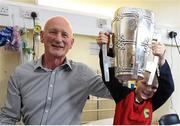 27 September 2014; Kilkenny manager Brian Cody with Jonah Fanning, age 7, from Wicklow, and the Liam MacCarthy Cup. Victorious Kilkenny Champions visit Our Lady's Children Hospital. Our Lady's Children Hospital, Crumlin, Co Dublin. Picture credit: Pat Murphy / SPORTSFILE