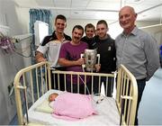 27 September 2014; Kilkenny's, from left, Colin Fennelly, Padraig Walsh, Conor Fogarty  and manager Brian Cody with five day old Aoife Baumann and her father Hans, from Midleton, Co. Cork. Victorious Kilkenny Champions visit Our Lady's Children Hospital. Our Lady's Children Hospital, Crumlin, Co Dublin. Picture credit: Pat Murphy / SPORTSFILE