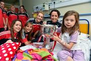 29 September 2014; Cork players, from left, Eimear Scally, Mairead Corkery, Briege Corkery and Geraldine Flynn, with six year old Amber O'Rourke, from Carlow town, and the Brendan Martin Cup during a visit to Temple Street Childrens Hospital, Dublin. Photo by Sportsfile