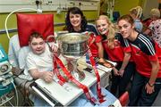 29 September 2014; Cork players, Norita Kelly, left, Vera Foley and Jean O'Sullivan, right, with fifteen year old Jake Naughton, from Rathangan, Co. Wexford, and the Brendan Martin Cup during a visit to Temple Street Childrens Hospital, Dublin. Photo by Sportsfile