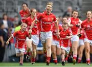 28 September 2014; Cork captain Briege Corkery runs onto the pitch with mascots James and Michael Twomey, from Aghinagh, Co. Cork, ahead of the game. TG4 All-Ireland Ladies Football Senior Championship Final, Cork v Dublin. Croke Park, Dublin. Picture credit: Ramsey Cardy / SPORTSFILE