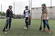 17 October 2014; Clare Hurler Shane O Donnell showcasing his hurling skills to delegates Jennifer Ong, left from California, USA, and Katie Vojir, from Pennsylvania, USA, from the One Young World Summit at Na Fianna GAA club, Glasnevin, Dublin. Picture credit: David Maher / SPORTSFILE