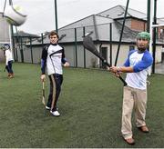 17 October 2014; Clare Hurler Shane O Donnell showcasing his hurling skills to delegate Leon Chen, China, from the One Young World Summit at Na Fianna GAA club, Glasnevin, Dublin. Picture credit: David Maher / SPORTSFILE