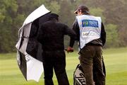 18 May 2007; David Higgins, Ireland, and his caddy Andy Daly take cover from the wind and rain on the 9th fairway during the 2nd Round. Irish Open Golf Championship, Adare Manor Hotel and Golf Resort, Adare, Co. Limerick. Picture credit: Matt Browne / SPORTSFILE