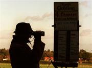 8 January 2000; A bookmaker uses binoculars to watch the course ahead of the Ladbroke Hurdle at Leopardstown Racecourse in Dublin. Photo by Damien Eagers/Sportsfile