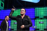 6 November 2014; Bono, Musician, Elevation Partners, returns a paper airplane to the crowd on the centre stage during Day 3 of the 2014 Web Summit in the RDS, Dublin, Ireland. Picture credit: Stephen McCarthy / SPORTSFILE / Web Summit