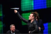 6 November 2014; Bono, Musician, Elevation Partners, throws a paper airplane into the crowd at the centre stage during Day 3 of the 2014 Web Summit in the RDS, Dublin, Ireland. Picture credit: Ramsey Cardy / SPORTSFILE / Web Summit