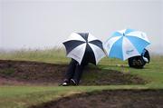 15 June 2007; Two spectators take shelter from the wind and rain during the Annual Gary Kelly Golf Classic. Baltray Golf Club, Co. Louth. Photo by Sportsfile