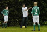 25 June 2006; Former Republic of Ireland star and 'Godfather' to this year's Irish team, Denis Irwin, met once again with the talented young Cherry Orchard team who will travel to Lyon to represent Ireland in less than a week's time at the Danone Nations Cup World Final. Irwin took the young team under his wing one last time to pass on his expertise and vast knowledge of International soccer. Pictured is Denis showing some tips to team members Kevin Nolan, left, and Stephen Coghlan. AUL Complex, Clonshaugh, Dublin. Picture credit: Brendan Moran / SPORTSFILE