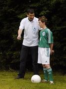 25 June 2006; Former Republic of Ireland star and 'Godfather' to this year's Irish team, Denis Irwin, met once again with the talented young Cherry Orchard team who will travel to Lyon to represent Ireland in less than a week's time at the Danone Nations Cup World Final. Irwin took the young team under his wing one last time to pass on his expertise and vast knowledge of International soccer. Pictured is Denis showing some tips to team member Sean Coyne, from Rathfarnham, Dublin. AUL Complex, Clonshaugh, Dublin. Picture credit: Brendan Moran / SPORTSFILE