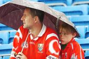 7 July 2007; Two fans take shelter from the rain during the game. Guinness All-Ireland Senior Hurling Championship Qualifier, Group 1B, Round 2, Cork v Offaly, Pairc Ui Chaoimh, Cork. Photo by Sportsfile