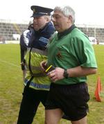 28 March 2004; Referee Sean McMahon is escorted off the field by Gardaí following the Allianz Hurling League Division 1B match between Cork and Tipperary at Pairc Ui Chaoimh in Cork. Photo by Brendan Moran/Sportsfile