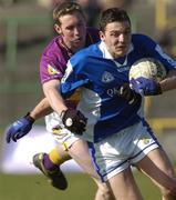4 April 2004; Ian Fitzgerald of Laois is tackled by Nicky Lambert of Wexford during the Allianz Football League Division 1B Round 7 match between Laois and Wexford at O'Moore Park in Portlaoise, Laois. Photo by Damien Eagers/Sportsfile