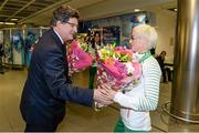 15 December 2014; Team Ireland's captain Ann Marie McGlynn, who won a team bronze medal in the Senior Women's event, is presented with a bunch of flowers by John Foley, Chief Executive, Athletics Ireland, in Dublin Airport on their return home from the Spar European Cross Country Championships in Bulgaria. Terminal 1, Dublin Airport, Dublin. Picture credit: Brendan Moran / SPORTSFILE