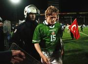 17 November 1999; Damien Duff of Republic of Ireland is led off the pitch by riot police after the UEFA European Championships Qualifier Play-Off Second Leg match between Turkey and Republic of Ireland at Ataturk Stadium in Bursa, Turkey. Photo by Brendan Moran/Sportsfile