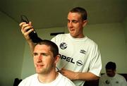 1 April 1999; Robbie Keane has his head shaved at the team hotel by team-mate Barry Quinn, due to the extreme heat, before a Republic of Ireland U20 Squad training sesssion at the Liberty Stadium in Ibadan, Nigeria. Photo by David Maher/Sportsfile