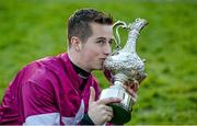 28 December 2014; Jockey Bryan Cooper celebrates with the Lexus Chase Perpetual Cup after winning the Lexus Steeplechase on his mount Road To Riches. Leopardstown Christmas Festival, Leopardstown, Co. Dublin. Photo by Sportsfile