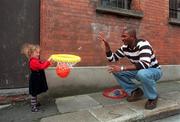 29 September 1999; Ciara O'Meara, age 3 and from Swords, holds the basket as Anthony Jenkins of Denny Notre Dame shoots a hoop at the launch of the ESB Superleague at Allsports Cafe in Temple Bar, Dublin. Photo by David Maher/Sportsfile