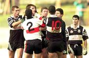 12 December 1999. Referee Brian White, partly hidden, tries to separate Paul Hanley of UCC, 2,  and Paul Hehir of Doonbeg, 10, during the AIB Munster Senior Club Football Championship Final match between UCC and Doonbeg at the Gaelic Grounds in Limerick. Photo by Brendan Moran/Sportsfile
